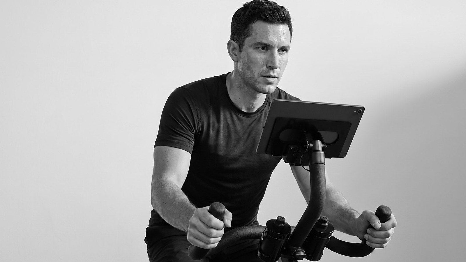 Rider in a dark tee riding a CAROL Bike, black and white