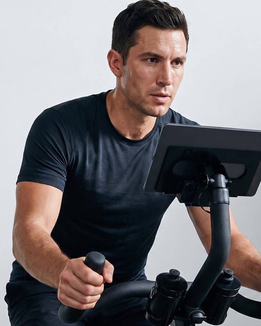 A rider at the console of a stationary bike, viewed from the front