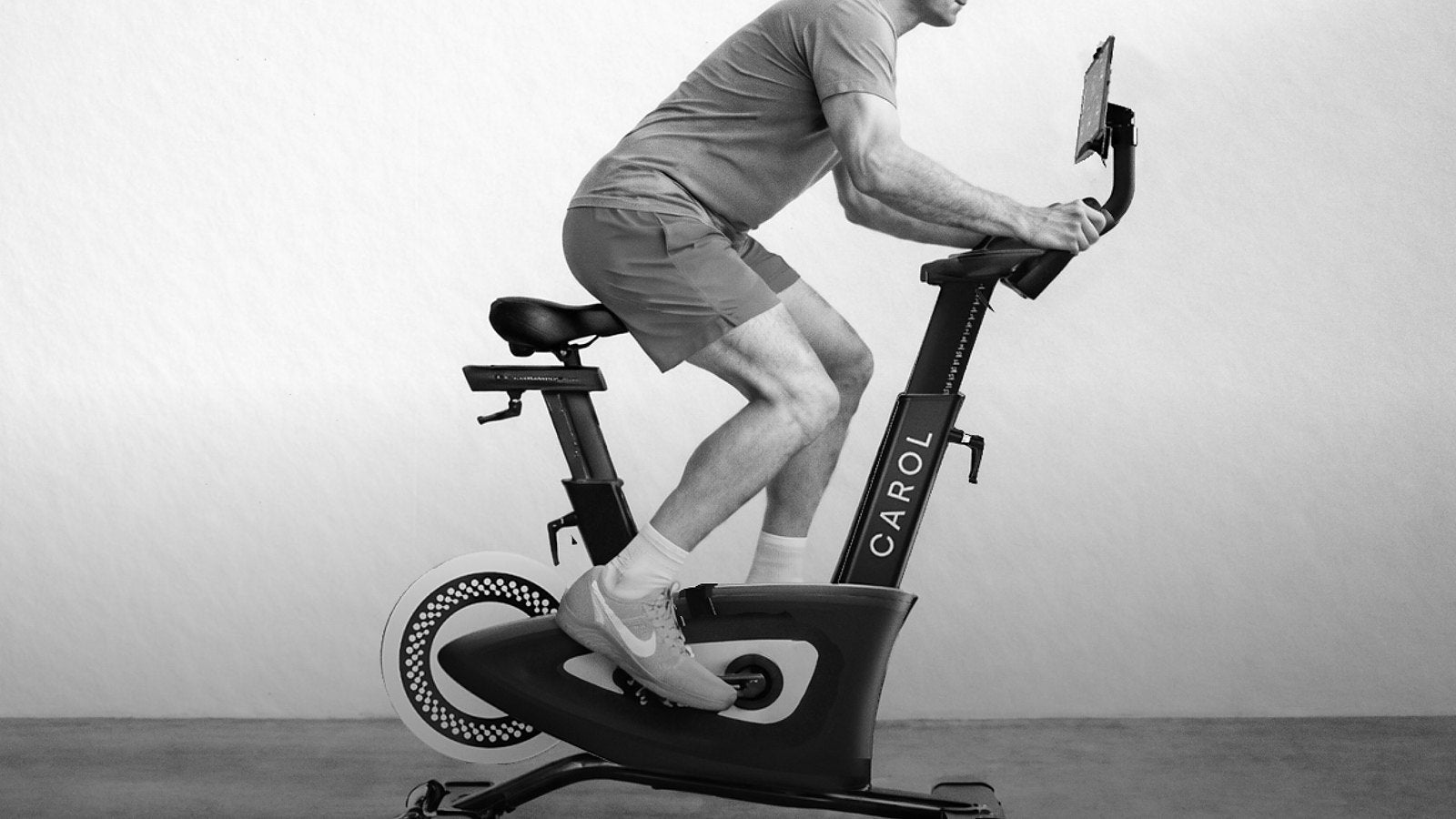 Rider in a light tee riding a CAROL Bike, seen from the side